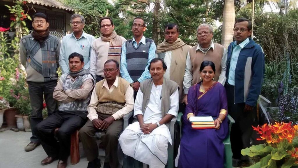 Group photo of teachers and school committee members of Bijoynagar Adarsha Vidyamandir (H.S) in a garden setting.