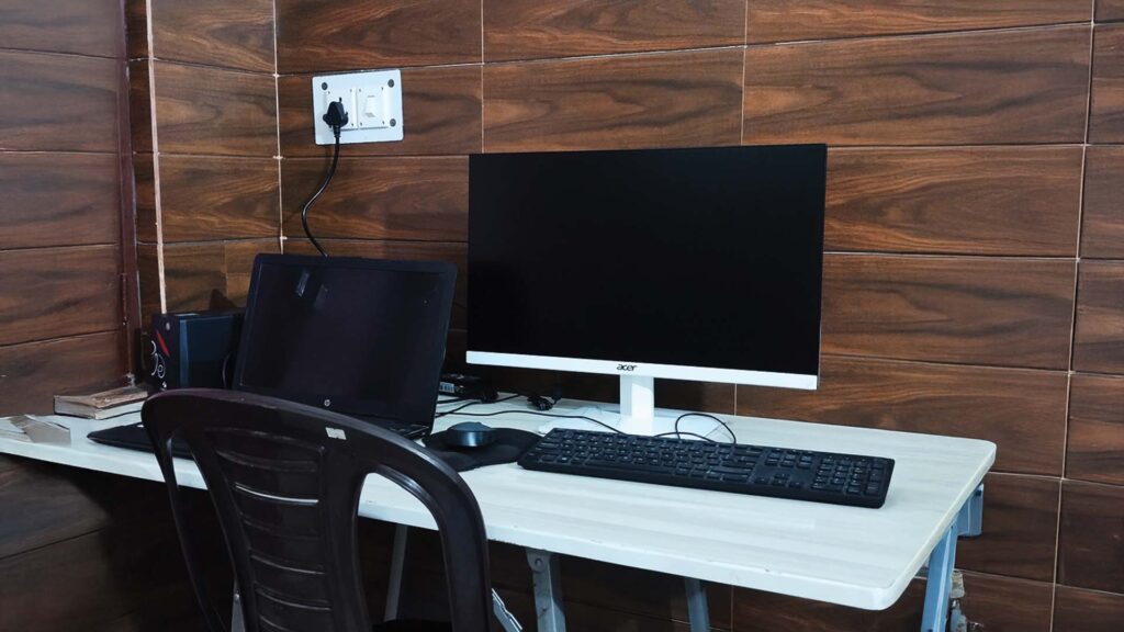 Custom-built desktop computer setup with Acer monitor and HP laptop on a white table
