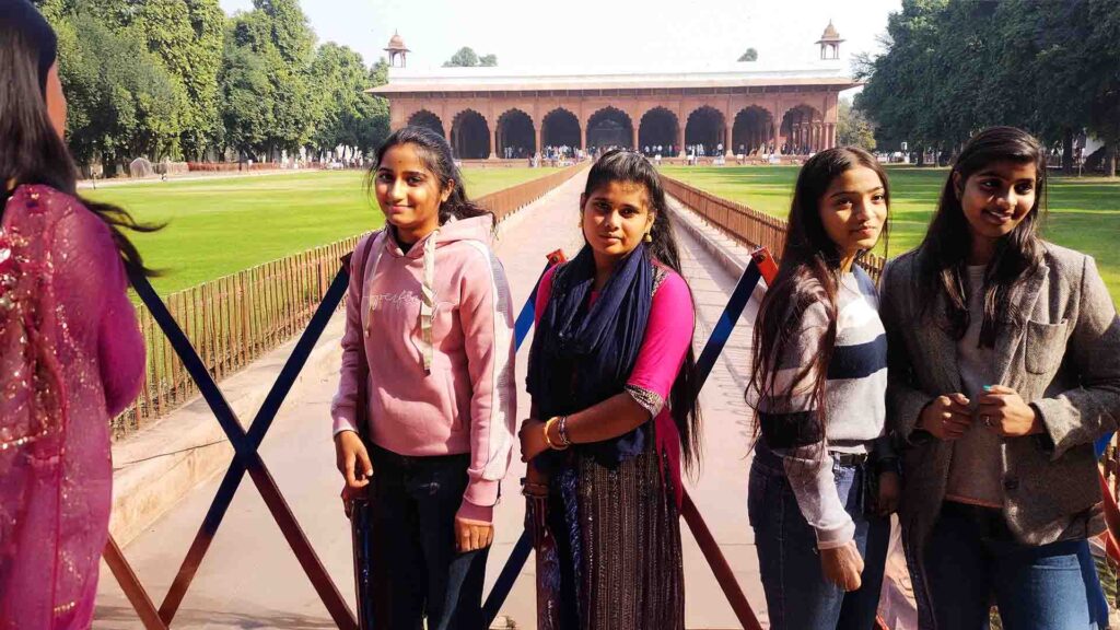 A group of young women standing in front of the Diwan-i-Aam (Hall of Public Audience) at the Red Fort, Delhi.